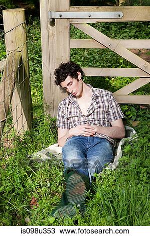 Stock Image - Young man asleep in countryside. Fotosearch