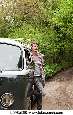 Young man by camper van View Large Photo Image Stock Photo - Young man by camper van. Fotosearch