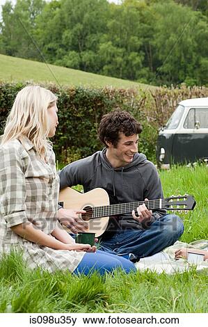Young man playing guitar to girlfriend View Large Photo Image Stock Photo - Young man playing guitar to girlfriend. Fotosearch
