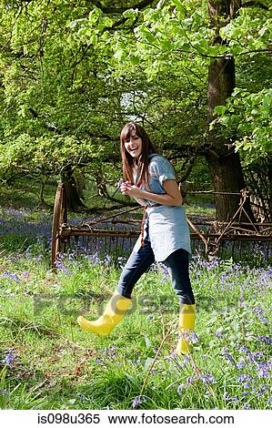 Stock Photography - Young woman in field of bluebells. Fotosearch