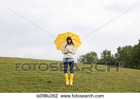 Young woman in field with umbrella View Large Photo Image Stock Image - Young woman in field with umbrella. Fotosearch