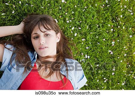 Young woman lying on grass View Large Photo Image Picture - Young woman lying on grass. Fotosearch