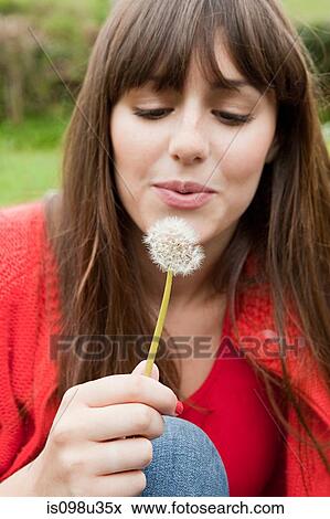 Stock Photo - Young woman with dandelion clock. Fotosearch