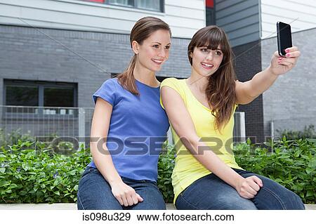 Friends using camera phone View Large Photo Image Stock Photo - Friends using camera phone. Fotosearch