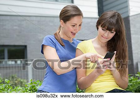 Friends using smartphone View Large Photo Image Stock Photo - Friends using smartphone. Fotosearch