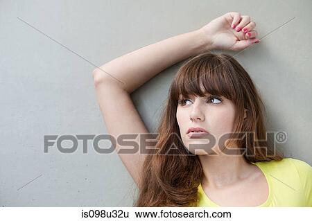 Portrait of a young woman with arm raised View Large Photo Image Stock Photograph - Portrait of a young woman with arm raised. Fotosearch
