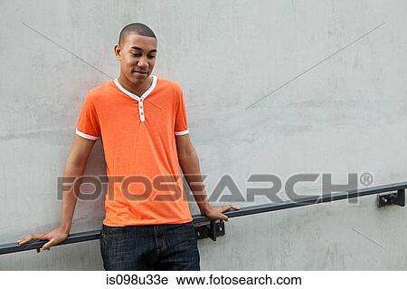 Stock Image - Young man by railing. Fotosearch