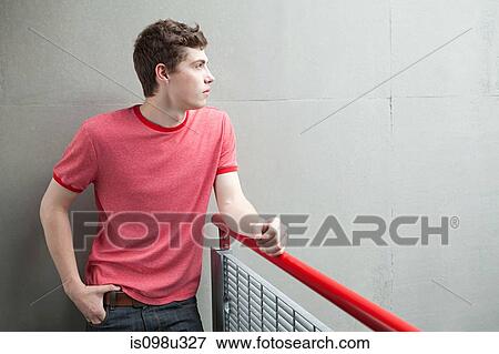 Young man by railing View Large Photo Image Stock Photo - Young man by railing. Fotosearch
