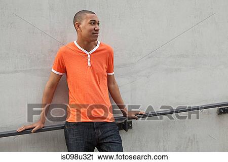 Young man by railing View Large Photo Image Stock Photograph - Young man by railing. Fotosearch
