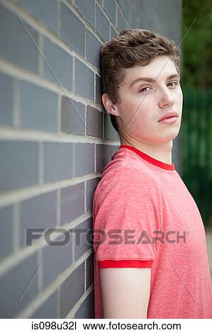 Young man by wall View Large Photo Image Stock Image - Young man by wall. Fotosearch