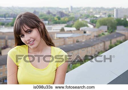 Young woman and urban scene in background View Large Photo Image Stock Photograph - Young woman and urban scene in background. Fotosearch
