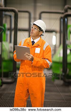 Engineer in factory with clipboard View Large Photo Image Picture - Engineer in factory with clipboard. Fotosearch