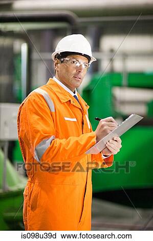 Engineer in factory with clipboard View Large Photo Image Stock Image - Engineer in factory with clipboard. Fotosearch