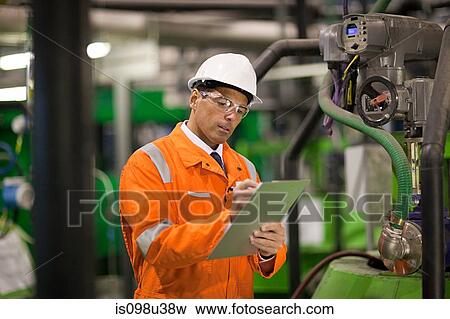 Engineer in factory with clipboard View Large Photo Image Stock Photo - Engineer in factory with clipboard. Fotosearch