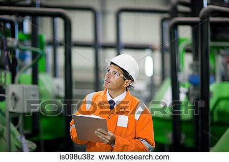 Stock Photo - Engineer in factory with clipboard. Fotosearch