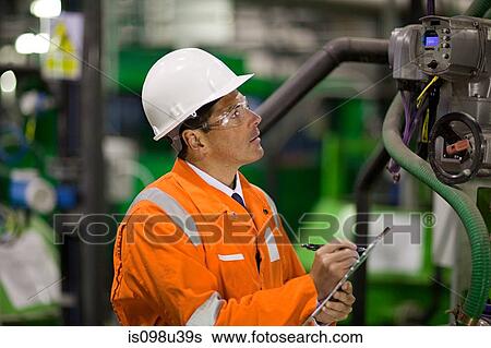 Engineer inspecting machinery in factory View Large Photo Image Stock Photograph - Engineer inspecting machinery in factory. Fotosearch