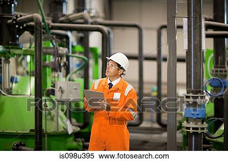 Engineer inspecting machinery in factory View Large Photo Image Stock Photography - Engineer inspecting machinery in factory. Fotosearch