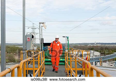 Engineer on walkway at industrial plant View Large Photo Image Stock Image - Engineer on walkway at industrial plant. Fotosearch