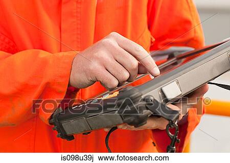 Engineer using handheld computer View Large Photo Image Stock Image - Engineer using handheld computer. Fotosearch