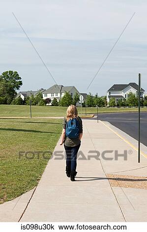 Female high school student walking along pavement View Large Photo Image Stock Image - Female high school student walking along pavement. Fotosearch