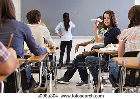 Female student with paper aeroplane in classroom View Large Photo Image Picture - Female student with paper aeroplane in classroom. Fotosearch