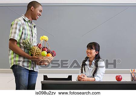Male high school student giving teacher a basket of fruit View Large Photo Image Stock Photo - Male high school student giving teacher a basket of fruit. Fotosearch