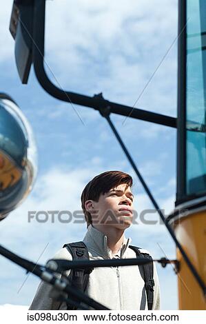 Male high school student standing outside school bus View Large Photo Image Picture - Male high school student standing outside school bus. Fotosearch