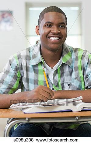Male high school student working in classroom View Large Photo Image Stock Photo - Male high school student working in classroom. Fotosearch