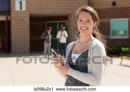 Stock Image - Female high school student outside school building. Fotosearch