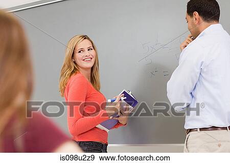 Stock Photo - High schcool teacher and student using white board. Fotosearch