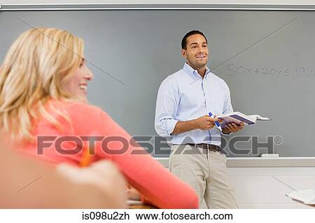Stock Image - High school teacher by white board. Fotosearch
