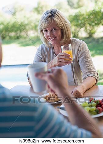 Picture - Couple having breakfast in garden. Fotosearch