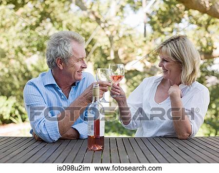 Couple toasting with wine outdoors View Large Photo Image Picture - Couple toasting with wine outdoors. Fotosearch