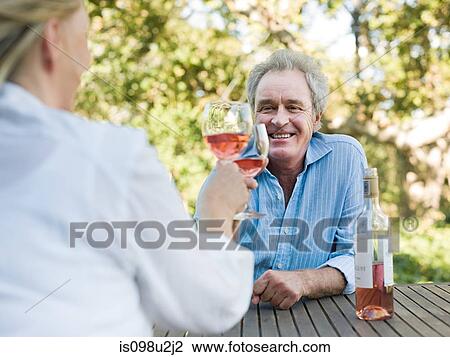 Stock Image - Couple toasting with wine outdoors. Fotosearch