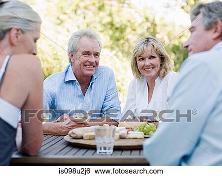 Stock Photograph - Friends at meal outdoors. Fotosearch