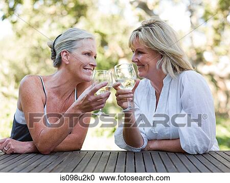 Stock Image - Friends toasting with wine outdoors. Fotosearch