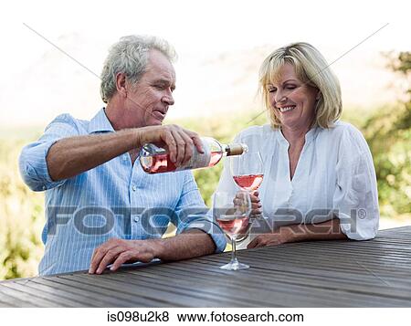 Stock Photo - Man pouring wine for woman. Fotosearch
