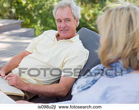 Mature couple on loungers in garden View Large Photo Image Stock Image - Mature couple on loungers in garden. Fotosearch