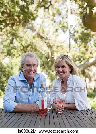 Mature couple outdoors with wine View Large Photo Image Stock Photo - Mature couple outdoors with wine. Fotosearch