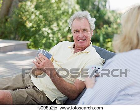 Mature couple playing cards outdoors View Large Photo Image Stock Image - Mature couple playing cards outdoors. Fotosearch