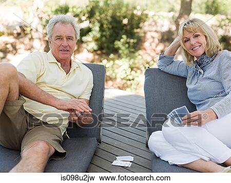 Stock Photo - Mature couple playing cards outdoors. Fotosearch