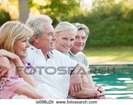 Mature friends by swimming pool View Large Photo Image Stock Photograph - Mature friends by swimming pool. Fotosearch