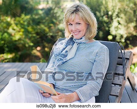 Mature woman on sun lounger with book View Large Photo Image Stock Photo - Mature woman on sun lounger with book. Fotosearch