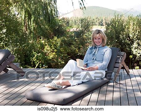 Mature woman on sun lounger with book View Large Photo Image Stock Photography - Mature woman on sun lounger with book. Fotosearch