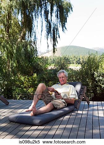 Stock Photography - Senior man on sun lounger. Fotosearch