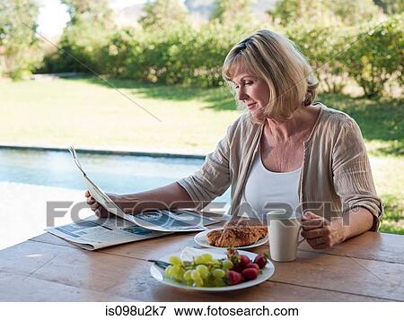 Woman outdoors with breakfast and newspaper View Large Photo Image Stock Photo - Woman outdoors with breakfast and newspaper. Fotosearch