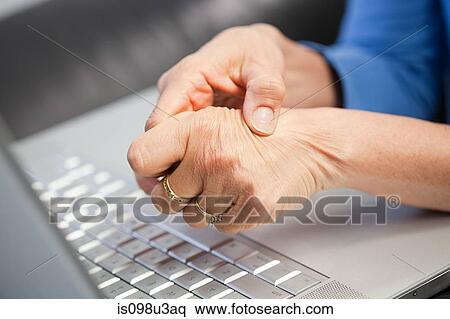 Stock Photography - Laptop and woman with pain in hand. Fotosearch