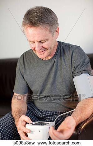 Man using blood pressure monitor View Large Photo Image Stock Photo - Man using blood pressure monitor. Fotosearch