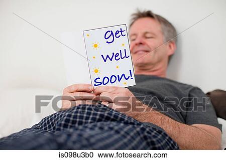 Stock Image - Man with get well soon card. Fotosearch