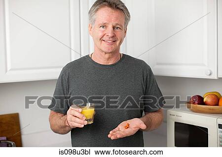 Stock Image - Man with vitamins and orange juice. Fotosearch